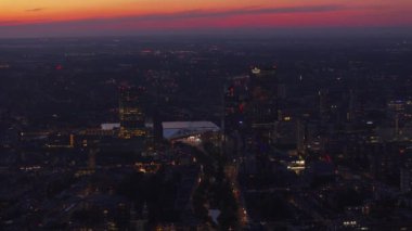 Gün batımında Rotterdam 'ın havadan görünüşü. Şehir ışıkları parlak gökyüzünün altındaki yüksek binaları ve sokakları aydınlatıyor. Şehir manzarası projeleri.