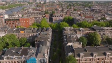 Amsterdam 'ın havadan görünüşü klasik mimari, yeşil ağaçlar ve parlak gün ışığı altında kanal su yolları.