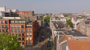 Amsterdam 'ın üzerindeki hava manzarası modern ve tarihi binaların karışımı, pitoresk bir kanala götürüyor. Aşağıdaki bisikletçiler ve yayalar.