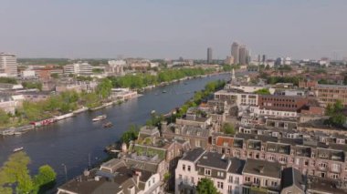 Güneşli bir günde büyüleyici binaları ve tekneleri olan Amsterdam Kanalları, şehrin su yolları ve mimarisini gözler önüne seriyor..