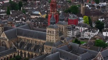 Maastricht 'in büyüleyici şehir manzarası, St Jans kilisesinin kırmızı kulesi, tarihi binalar ve yemyeşil alanlar. Ortaçağ yapıları ve simgeleriyle dolu canlı bir manzara..
