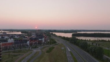 Gün batımında Hollanda 'da bir sahil kasabasının hava manzarası, manzaralı bir rıhtım manzarası, düzgün yollar ve huzurlu manzaralarla çevrili antika evler..
