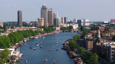 Amsterdamlar büyüleyici kanallar, sergilenen tekneler, yeşillik ve büyüleyici bir hava perspektifinden modern ve tarihi mimarinin bir karışımı..