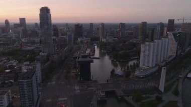 Gökdelenler, su yolları ve kentsel mimari ve tasarımı aydınlatan hareketli caddelerle gündoğumunda Rotterdam 'ın çağdaş şehir manzarasının çarpıcı hava manzarası.