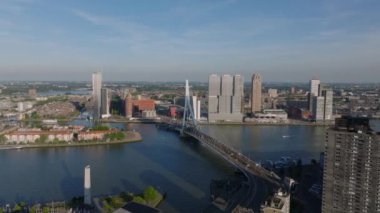 Güneşli bir günde ikonik Erasmus Köprüsü ve modern binaların yer aldığı Rotterdam 'ın gökyüzü manzarası. Şehir manzaraları ve seyahat yerleri.