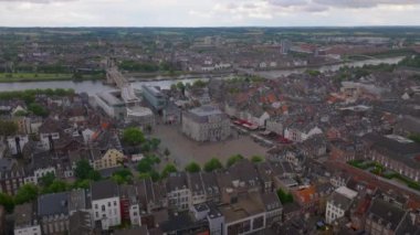 Yukarıdan Maastricht, zengin tarihini, canlı şehir manzarasını, belediye binasını ve akan nehri vurguluyor. Seyahat ve turizm temaları.