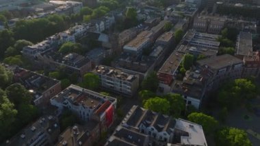 Gün batımında Rotterdam yerleşim alanının hava manzarasında yeşil ağaçlar ve tarihi binalar var. Kentsel ve seyahat temaları.