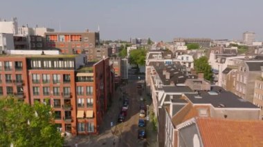 Amsterdam 'ın üzerindeki hava manzarası modern ve tarihi binaların karışımı, pitoresk bir kanala götürüyor. Aşağıdaki bisikletçiler ve yayalar.