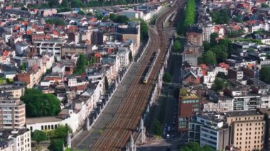 Sarı tren, Antwerp Merkez İstasyonu 'na yaklaşırken çarpıcı bir şehir manzarası sergiliyor. İçi canlı mimari ve hareketli şehir hayatı ile dolu. Resimli bir yaz ortamı..