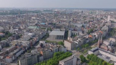 Antwerp şehir merkezinde, parlak bir yaz gününde caddelerde gezinen arabaların arka planda akan Scheldt Nehri ile canlı kent manzarası gelişiyor..