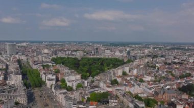 Antwerp, Belçika 'nın kentsel yayılımını gösteren geniş bir şehir manzarası var. Odak yeşil yemyeşil bir parka kayıyor ve etrafındaki beton ormanla tamamen zıtlaşıyor..