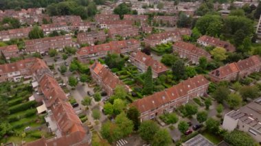 Havadan bakıldığında, Brüksel 'de kırmızı çatıları ve canlı yeşil bahçeleri olan ve büyüleyici bir çevrede yaşayan kentsel yaşamı vurgulayan evlerin sergilendiği alçak bir yerleşim alanı görülüyor..