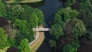 Antwerp 'te canlı yeşil bir parkın yer aldığı hava perspektifinde, bir gölet ve yayaların geçtiği büyüleyici bir köprü yer alıyor..