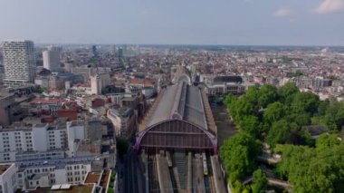Antwerp Merkez İstasyonu 'nun yüksek görüş açısına sahip kemerli çatısı var. Aşağıdaki caddelerde arabalar sürüyor ve trenler platformlara varıyor..