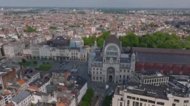 Kubbesi ve kulesi olan Antwerp Merkez İstasyonu, kaldırımlarda yürüyen arabaları ve yayaları olan yoğun bir şehir merkeziyle çevrilidir..