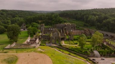 Villers Abbey harabeleri yemyeşil bir ormanla çevrilidir. Antik taş duvarlar ve kemerler, antik yapıyı ortaya çıkarıyor..