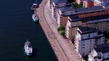 Stockholm rıhtımında kayıklar süzülüyor. Turistler ve yerliler bu canlı şehir merkezinde güneşli bir yaz gününün tadını çıkarırken..