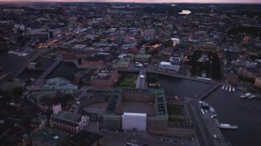 Stockholm şehir merkezinin mavi saatte aydınlattığı hava manzarası Kraliyet Sarayı 'nı ve kanalları teknelerle aydınlatıyor..