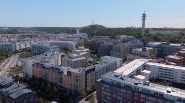 Çatı katları Stockholm 'un canlı bir yaz manzarası, yeşil tepeler ve arka planda bir haberleşme kulesi içinde konutlar ve parklar olduğunu gösteriyor..