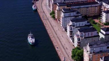 Stockholm, İsveç rıhtımına yaklaşan bir feribotun hava görüntüsü. Turistler ve yerliler gezintide güneşli bir günün tadını çıkarıyorlar..