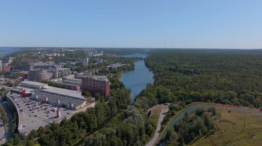 Stockholm 'un binalar, bir göl ve bir ormanla çevrili havadan manzarası. Kamera soldan sağa dönüyor, şehre farklı açılardan bakıyor..