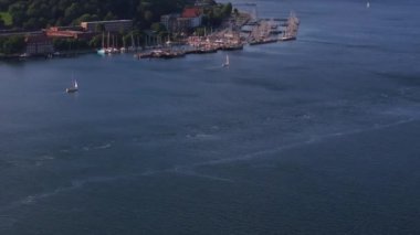 Hava görüntüleri, Almanya 'nın Kiel kentinde çeşitli boyutlarda teknelerle dolu bir marinayı yakalıyor. Yelkenliler, canlı deniz atmosferini vurgulayarak limana doğru süzülür..