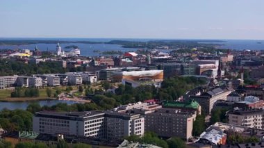 Helsinki, Finlandiya şehir merkezi üzerinde hava manzarası. Kamera, şehir manzarasını merkez kütüphanesi Oodi ile gösteriyor..