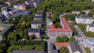 Stockholm, İsveç havadan izleniyor. Kırmızı çatıları olan konut binaları canlı yaz mevsiminde canlı yeşil ağaçlarla uyumlu hale gelir..