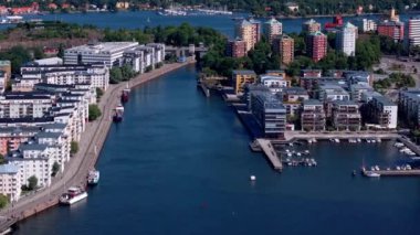 Stockholm limanının havadan görüntüsü su üzerinde seyahat eden tekneleri ve rıhtım boyunca renkli apartmanlar gösteriyor..
