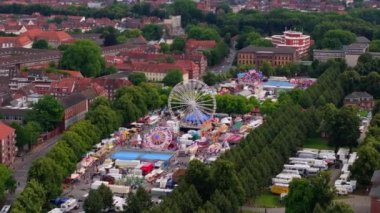 Munster, Almanya 'nın kuş bakışı manzarası, canlı çadırlar ve neşeli kalabalıklarla çevrili büyük bir dönme dolap ile canlı bir yaz festivali yakalıyor..