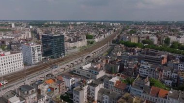 Belçika 'nın Antwerp kentindeki birçok bina ve tren yolu bulunan yoğun bir şehir manzarası. Sokakta arabalar sürüyor ve bazı bitkiler görünüyor..