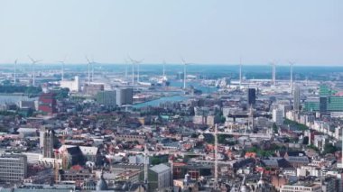 Antwerp şehrinin ufuk çizgisi yukarıdan görüldüğü gibi sağa doğru yavaş bir tavayla. Scheldt nehri ve bir sıra rüzgar türbini uzaktan görülebiliyor..