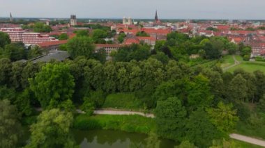 Munster, Almanya şehir parklarında ve şehir arka planında büyüleyici yeşil ağaçlar ve büyüleyici kırmızı çatılar sergiliyor..