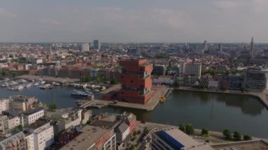 Hava görüntüleri MAS Müzesi aan de Stroom ve canlı şehir Antwerp 'i vurguluyor. Arabalar açık mavi gökyüzünün altında işlek caddelerde dolaşırken gemiler Scheldt Nehri boyunca süzülüyor..