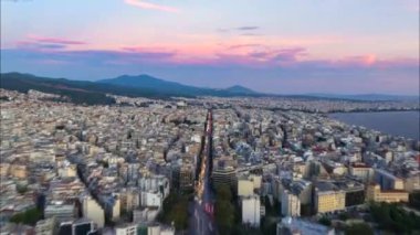 Hiperlapse, günbatımında Yunanistan 'ın Selanik kentini canlandırıyor. Şehir merkezinden Ege Denizi 'ne uzanan yoğun bir yol boyunca trafik ilerliyor..