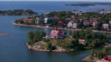 Renkli binalar, restoran binaları, tekneli bir liman ve güneşli bir yaz gününde yemyeşil bir liman olan Helsinki Adası 'nın hava manzarası..