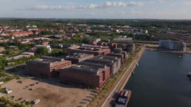 Almanya 'nın Kiel fiyortundaki modern binalar. Limanda yeşil ağaçlar ve arka planda diğer binalarla dolu tekneler var..