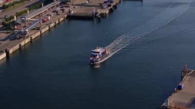 Almanya, Kiel limanından ayrılan bir teknenin hava görüntüsü. Feribot sakin sularda yüzüyor, arkasında beyaz bir iz bırakıyor..