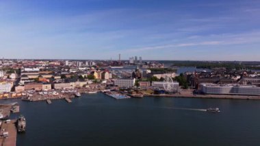 Helsinki şehir merkezinde hava manzarası sergileniyor. Manzarayı gözler önüne seriyor. Güneşli bir yaz gününde Baltık Denizi 'nde, hareketli rıhtımların yakınında gemiler zarifçe yelken açar..
