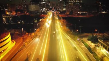 Modern kentsel bölgedeki çok şeritli yolun ortasındaki raylarda giden metro trenini takip ediyoruz. Geceleri La Defans 'ta gökdelenler. Paris, Fransa. Arttırılmış gerçeklik görsel efektleri.