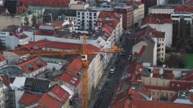 Tarihi binalar ve Berlins şehrindeki işlek caddeler arasında bir vinç ve şantiye manzarası.