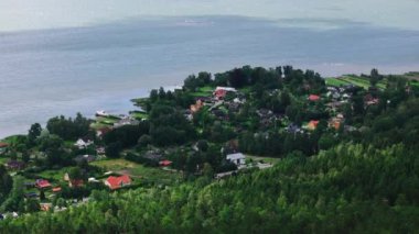 Göz kamaştırıcı İsveç takımadalarının arasına yerleşmiş pitoresk bir ada kasabasının sakin hava manzarası. Bereketli yeşillikler, büyüleyici evler ve ışıl ışıl mavi sular cennet gibi bir yaz manzarası yaratır..