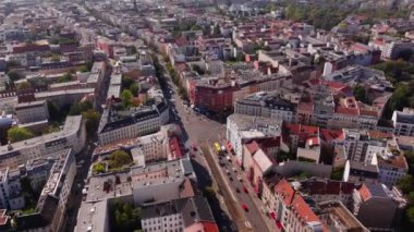 Berlin 'in aydınlık bir günde gökyüzünü gösteren hava manzaraları, şehir simgelerini ve canlı yeşil ağaçları vurguluyor, canlı bir şehir manzarası yaratıyor..