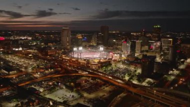 St. Louis Cardinals 'ın evindeki Busch Stadyumu' nun havadan görünüşü, arka planda şehir ışıkları ve gökdelenlerin yer aldığı bir beyzbol maçı sırasında. St. Louis, Missouri, ABD, 10 Nisan 2024