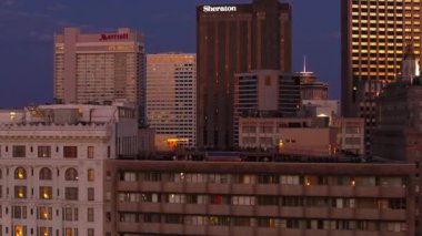 Alacakaranlıkta New Orleans 'ın gökyüzü manzarası Sheraton binasının şehir manzarasını aydınlatmasıyla aydınlanıyor. Canlı şehir atmosferi ve modern mimari New Orleans ABD Nisan 12024