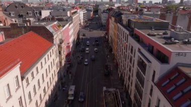 Kamera Berlin, Almanya 'da işlek bir caddeye yükseliyor. Arabalar ve otobüsler yol boyunca gider. Alexanderplatz 'daki Iconic Fernsehturm televizyon kulesi uzaktan görülebiliyor..