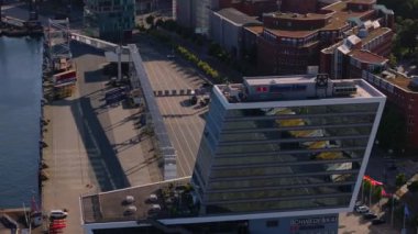 Stena Hattı binasının bulunduğu Kiel limanını hava görüntüleriyle görüyoruz. Tekneler suda dolaşır, canlı bir deniz aktivitesi ve kentsel canlılık manzarası yaratır..