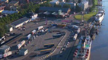 Finlandiya 'da Turku limanını gösteren hava manzarası. Büyük beyaz bir gemi rıhtımda dinlenirken, kamyonlar ve arabalar sıraya girip feribota binmeyi bekliyor..