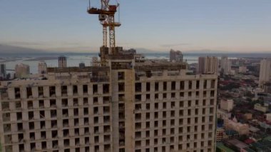 Manila 'da terk edilmiş bir inşaat alanının arka planında vinçler ve şehir silueti olan hava görüntüsü kentsel kalkınma projelerini gözler önüne seriyor..
