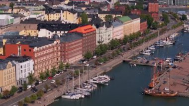 Helsinki limanının havadan görünüşü. Tekneler yavaşça suyun üzerinde sallanıyor. Turistler ve yerel halk, Finlandiya 'nın başkentinde güneşli bir günün tadını çıkarıyorlar..